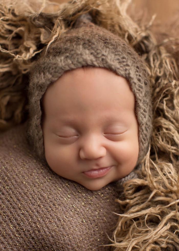 A photo of a baby smiling in her sleep.