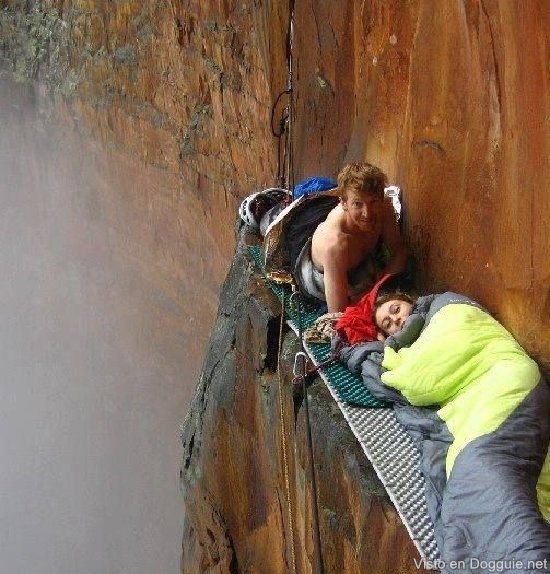 A man and a woman, who are not afraid of heights sleep on the cliff edge.